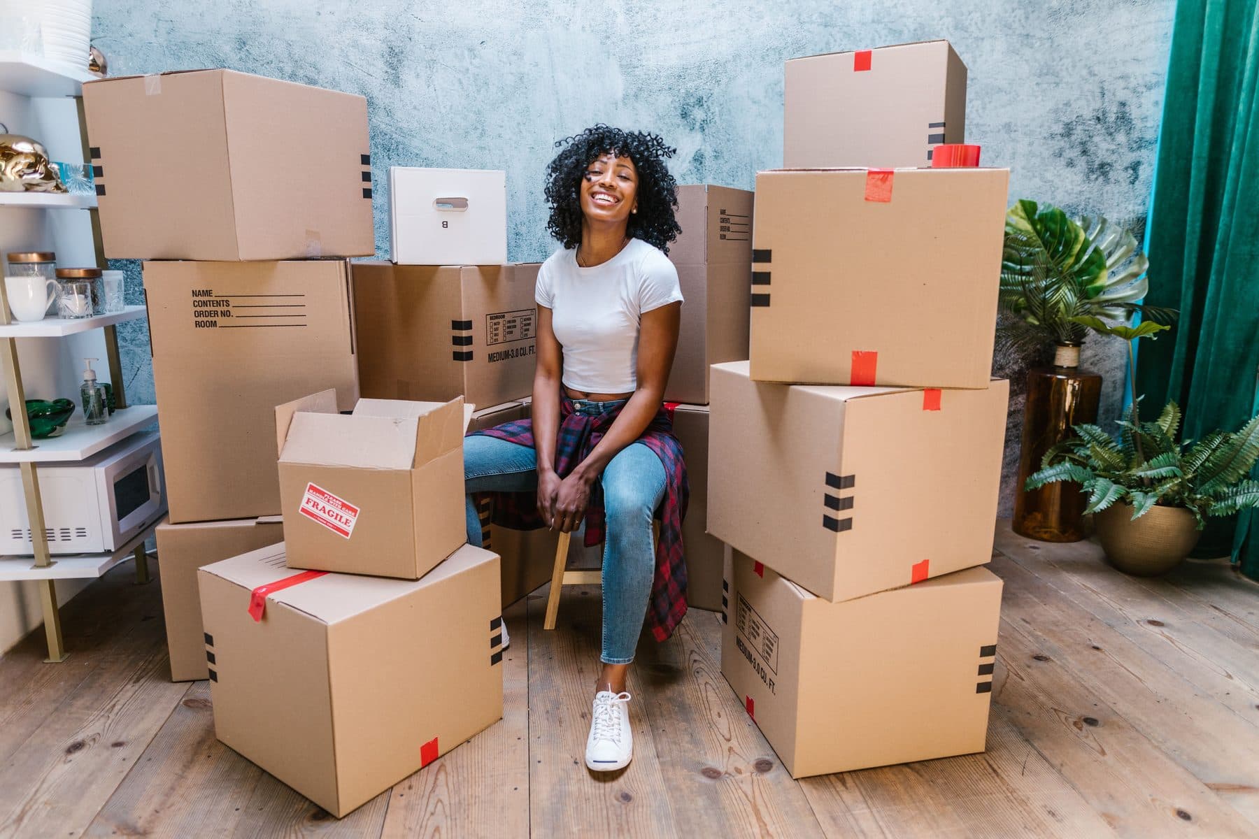 Une dirigeante de PME souriante, entourée des cartons d'une commande prête à être livrée